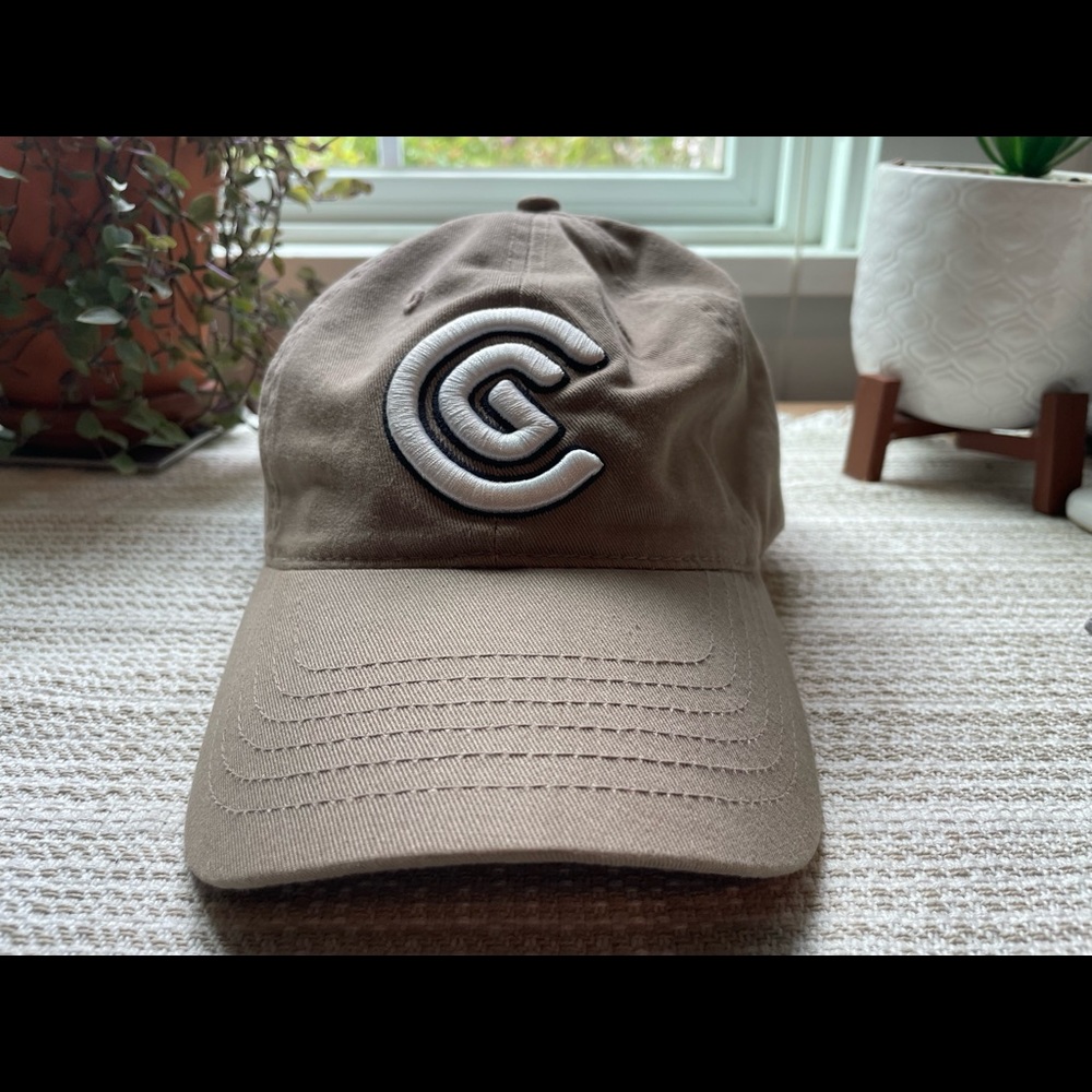 Cleveland Golf tan and white ball cap.